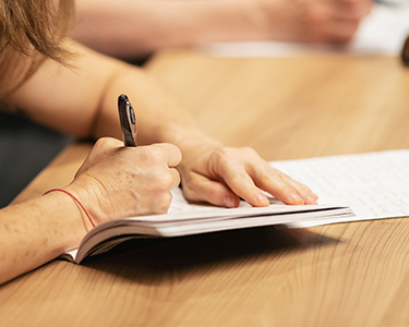 Image of someone writing in their notebook