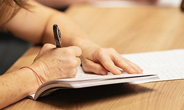 Image of someone writing in their notebook